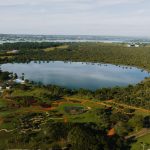 Vista aérea do Lago Paranoá, em Brasília, cercado por áreas verdes.