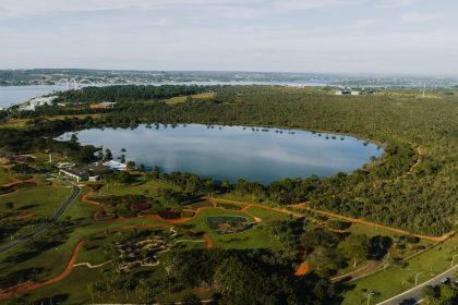 Vista aérea do Lago Paranoá, em Brasília, cercado por áreas verdes.