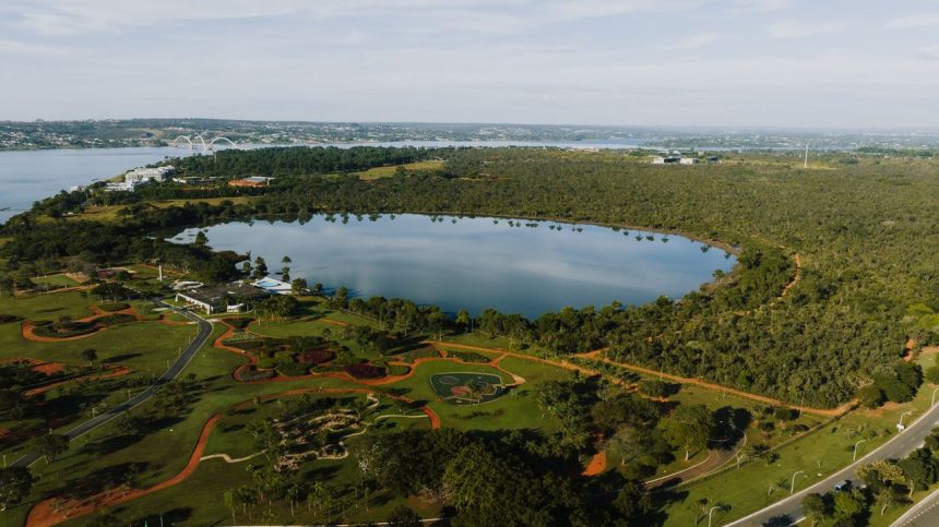 Vista aérea do Lago Paranoá, em Brasília, cercado por áreas verdes.